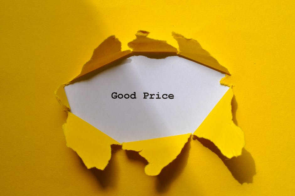 A yellow sheet of paper with a torn irregular hole revealing a white note inside, on which the words 'Good Price' are typed in black text. The torn edges of the yellow paper curl outward and cast shadows, indicating the paper's thickness. The background is a solid yellow surface matching the torn paper, creating a contrast with the white note. The scene appears to be arranged to emphasize the message of value or affordability, indirectly relating to the context of rubbish removal and cost-effective waste management services. The lighting is even, highlighting the texture of the torn paper and the clean appearance of the text, with no additional objects or clutter visible around the paper, maintaining a clear and neutral presentation.